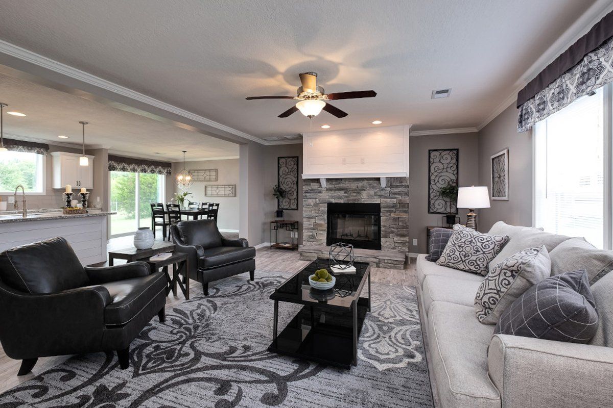 a living room with a couch , chairs , coffee table and fireplace .